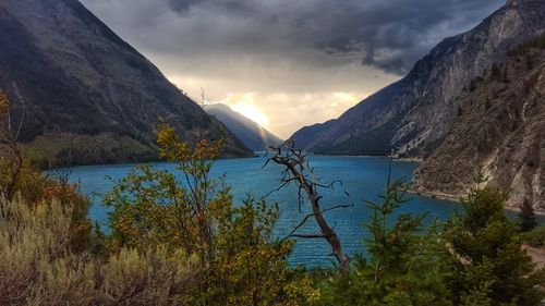 Scenic view of mountains and lake against cloudy sky