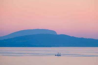 Scenic view of lake against mountains during sunset