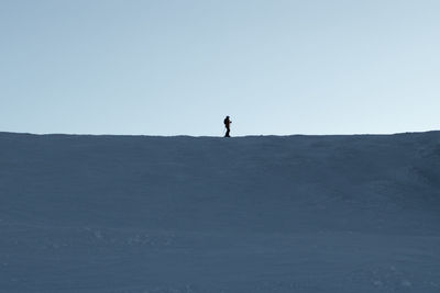 Silhouette person standing on field against clear sky