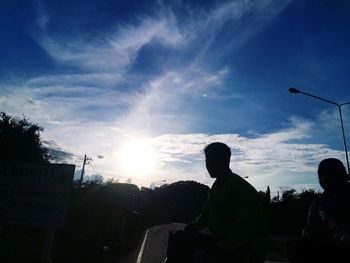 Silhouette man standing by tree against sky during sunset