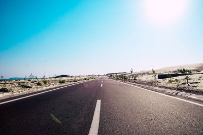 Surface level of road against blue sky