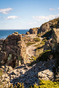 Rock formations by sea against sky