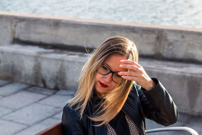 Blond woman sitting outdoors