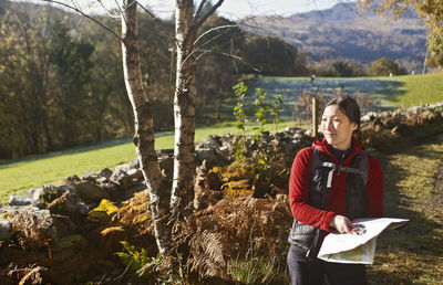 Mature female hiker reading map