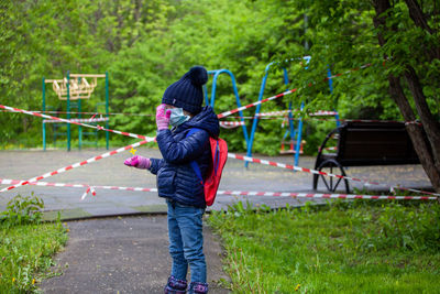 Full length of girl standing against plants at park