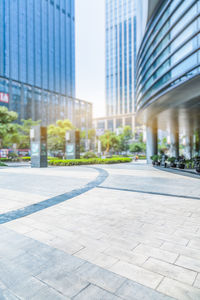 Footpath by modern buildings in city