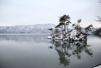 Scenic view of lake against sky during winter