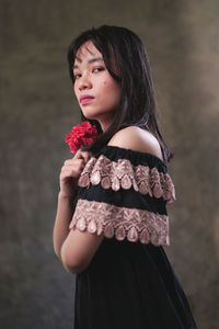 Woman looking away while standing against blurred background