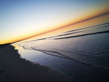 Scenic view of beach against sky during sunset