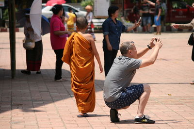 Rear view of people walking on footpath