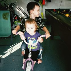 Siblings on bicycle at home