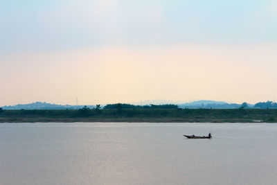 Side view of boats in sea against sky