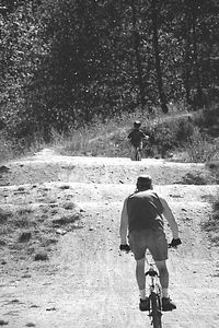 Rear view of man and woman walking on field