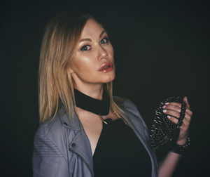 Close-up of young woman against black background