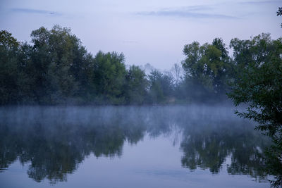 Reflection of trees in lake against sky