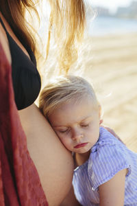 Girl listening to pregnant mothers stomach
