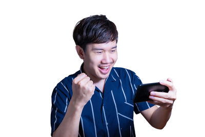 Portrait of smiling man holding camera against white background