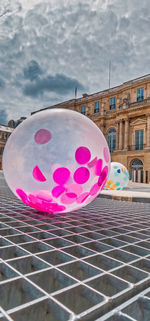 Close-up of pink balloons against building in city