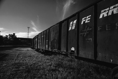 Train on railroad track amidst field against sky