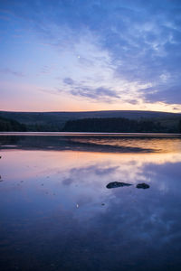 Scenic view of lake against sky at sunset