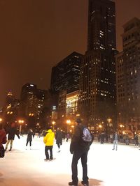 People on snow covered city at night