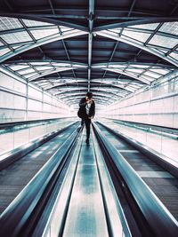 Rear view of man on escalator
