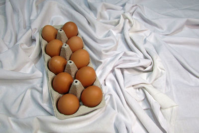 High angle view of eggs in container on bed