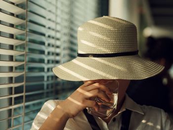 Close-up of woman drinking water at home