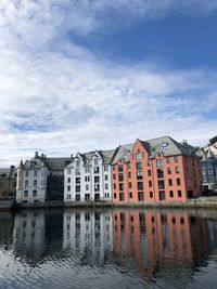 Reflection of buildings in canal against sky