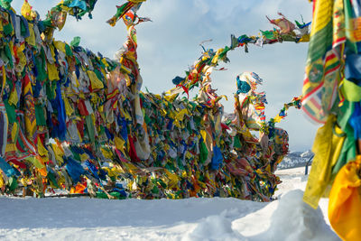 Prayer flags with tibetan mantras in wind at snowy temple complex, asian culture at local monastery