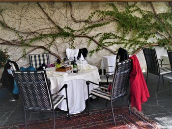 Chairs and tables at sidewalk cafe against clear sky