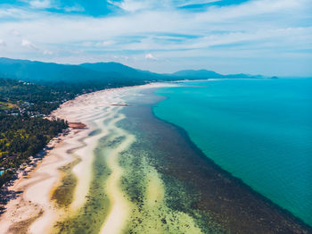 Scenic view of sea by mountains against sky