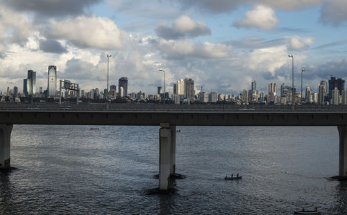 Scenic view of river by buildings against sky