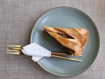Apple pie with knife fork on plate on table