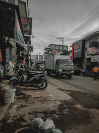 Cars on street against buildings in city during winter