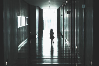 Rear view of woman walking in corridor