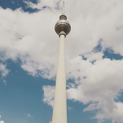 Low angle view of fernsehturm against cloudy sky