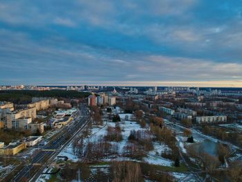 High angle view of city buildings against cloudy sky