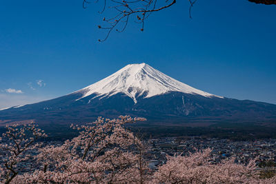 Scenic view of snowcapped mountains against blue sky