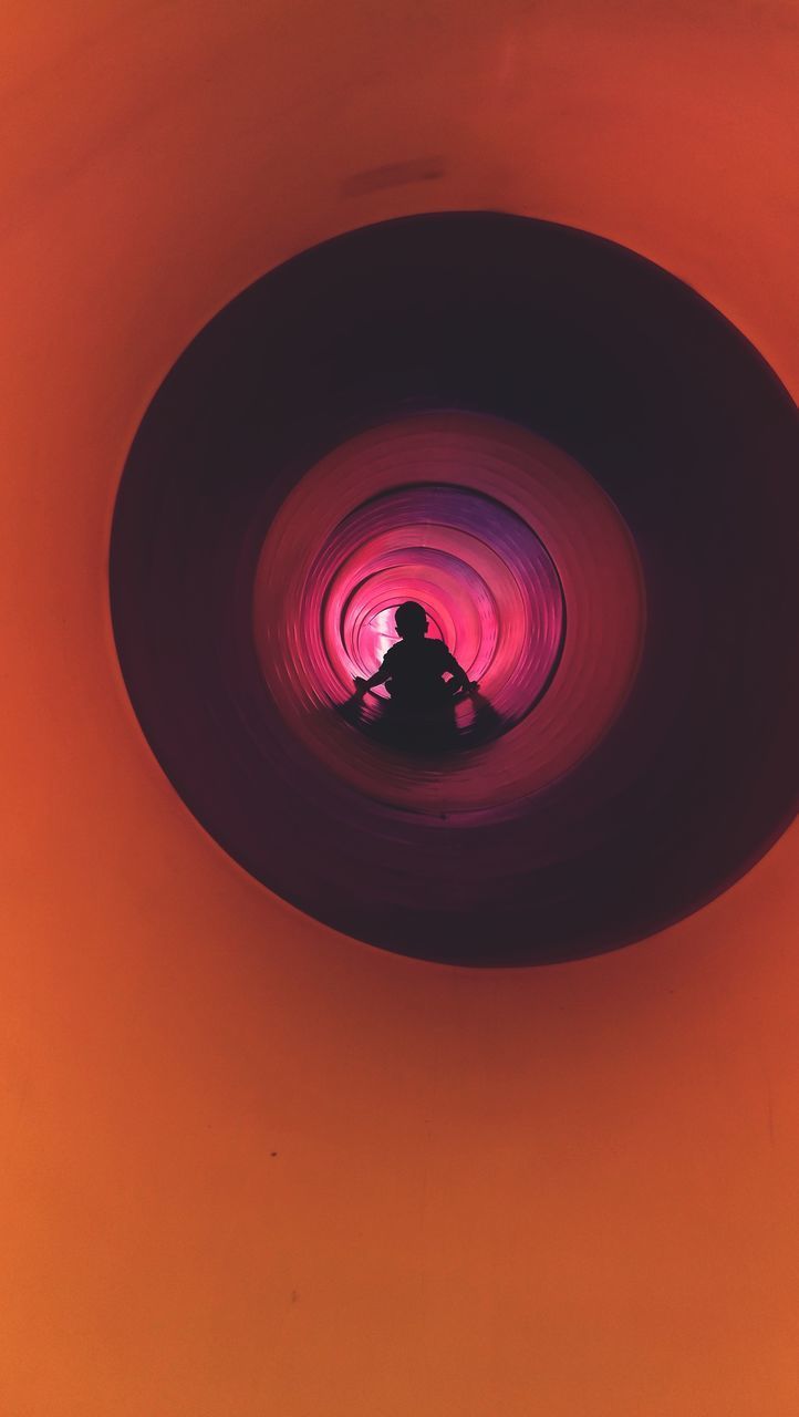 SILHOUETTE OF PERSON PHOTOGRAPHING ILLUMINATED ORANGE