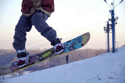 Low section of man riding bicycle on snow