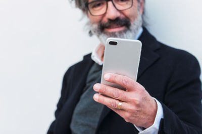 Senior businessman with glasses using mobile phone, typing message, cropped male in elegant suit