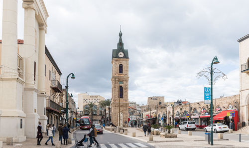 Buildings in city against cloudy sky