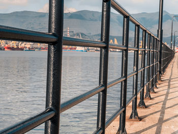Railing by sea against sky
