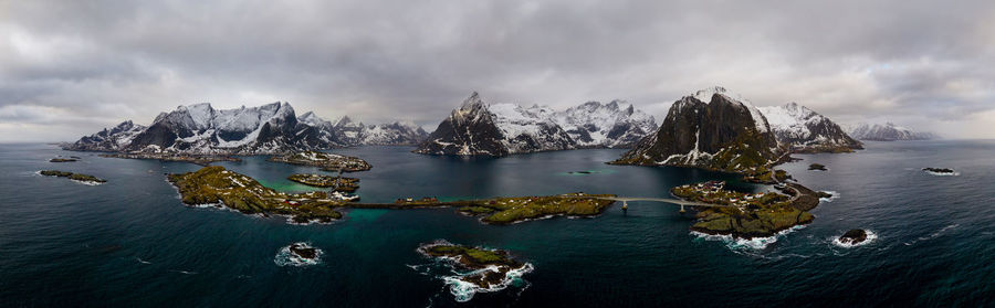 Panoramic view of sea and snowcapped mountains against sky