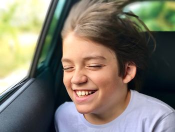 Close-up of smiling boy in car