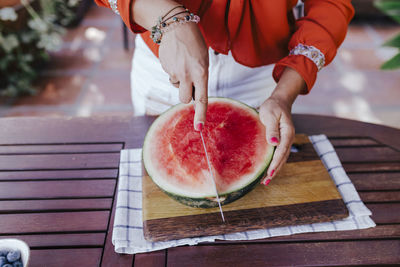 Midsection of woman holding apple on table