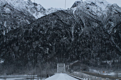 Falling snow on bridge with mountain winter background