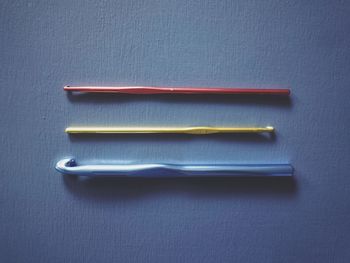 High angle view of colored pencils on table against blue background