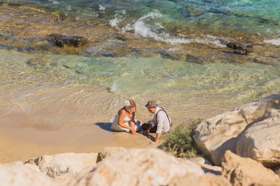 High angle view of people on rocks at beach